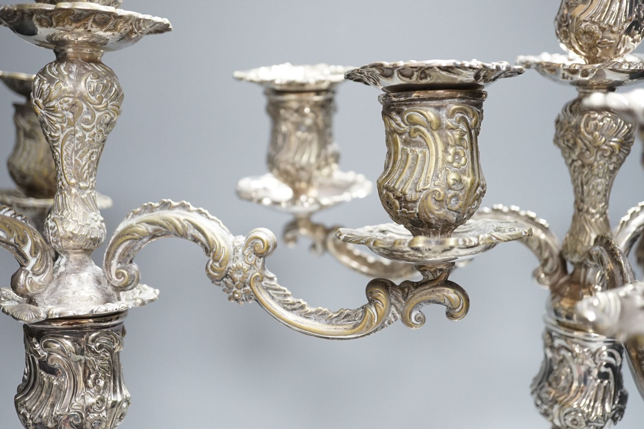 A pair of plated embossed three branch candelabra, 43cm